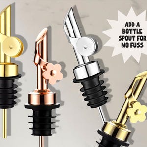 May include: Four metal bottle spouts in gold, copper, and silver tones. Each spout has a black rubber stopper. One gold spout has a flower accent. Text reads: ADD A BOTTLE SPOUT FOR NO FUSS.
