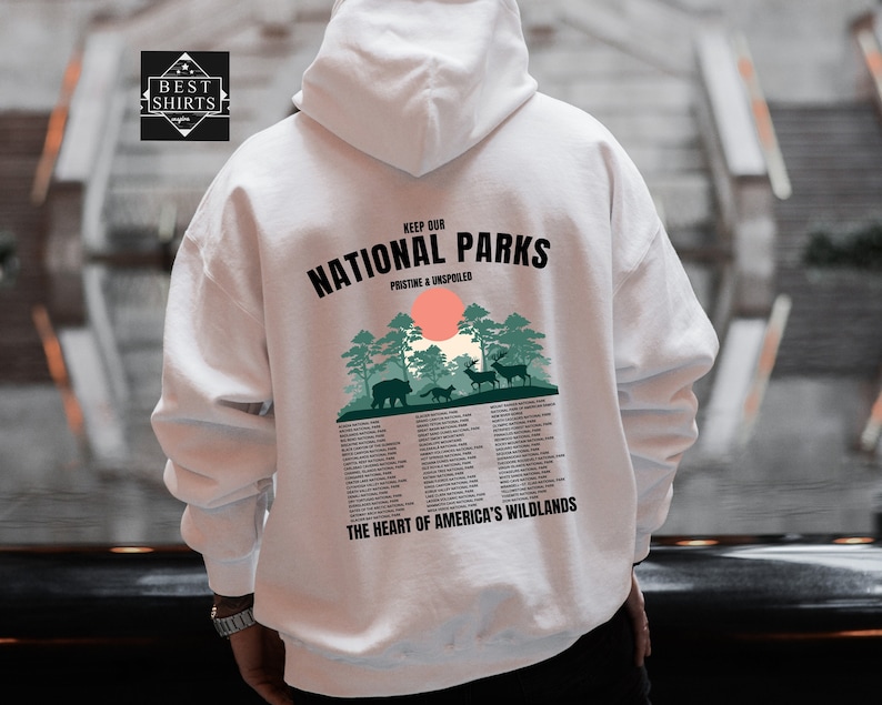 May include: White hooded sweatshirt with a graphic print of a forest scene with the text "Keep Our National Parks Pristine & Unspoiled" and a list of national parks. The graphic also includes a bear, a fox, and two deer.
