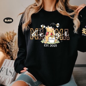 May include: Black sweatshirt with a Winnie the Pooh graphic and the text "Be a Mama Est. 2025".