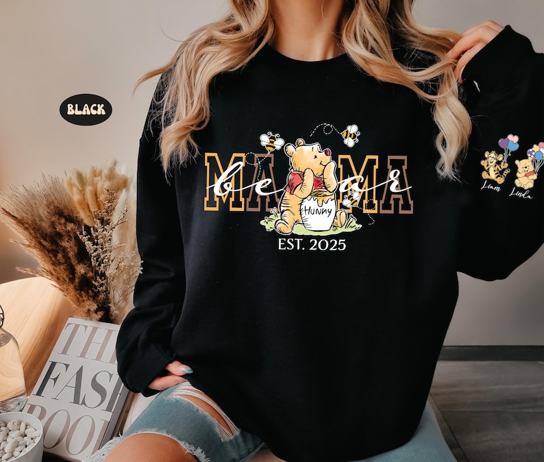May include: Black sweatshirt with a Winnie the Pooh graphic and the text "Be a Mama Est. 2025".