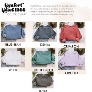 May include: A color chart displays Comfort Colors 1566 sweatshirts in various colors. The colors include blue jean, denim, crimson, white, light green, orchid, and pepper. The text describes the garment's features.