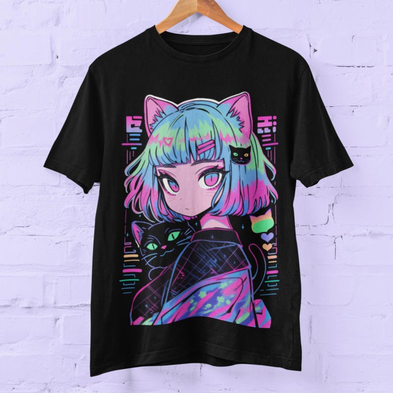 May include: Black t-shirt with a colorful graphic print of a girl with blue and pink hair holding a black cat. The girl is wearing a colorful patterned jacket and has cat ears. The graphic is surrounded by a neon pink, blue, and green geometric pattern.
