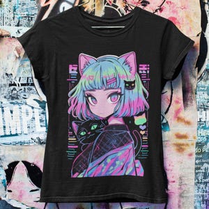 May include: Black t-shirt with a colorful anime-style illustration of a girl with blue hair and cat ears. She is holding a black cat with green eyes. The design includes a rainbow and hearts.