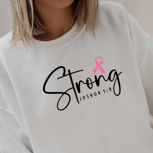 May include: White sweatshirt with a pink ribbon and the text "Strong Joshua 1:9" printed on the front.