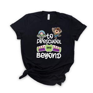 Pode incluir: Camiseta preta com um gr&aacute;fico branco de Woody e Buzz Lightyear de Toy Story. O gr&aacute;fico diz "To Preschool and Beyond".
