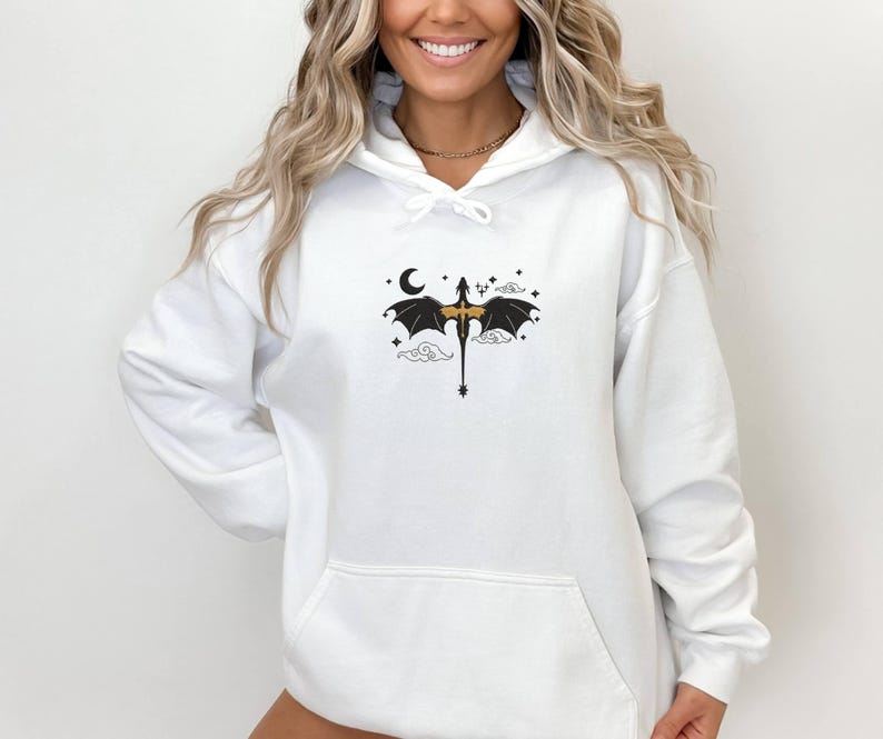 May include: White hoodie featuring a black and gold dragon graphic. The dragon is flying with its wings spread and a crescent moon is in the background.