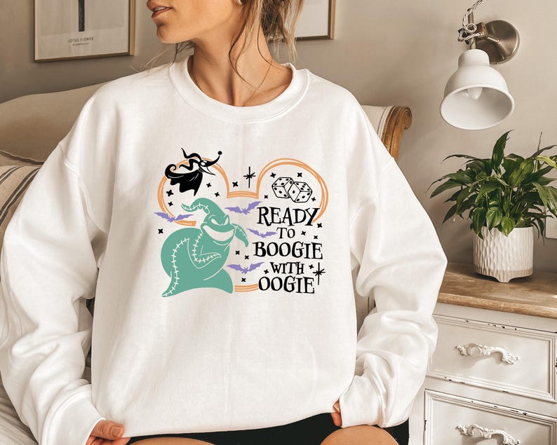 Pu&ograve; includere: Felpa bianca con un design di Oogie Boogie color turchese e la scritta "Ready to Boogie with Oogie". Il design include pipistrelli, dadi e Jack Skellington. Una divertente felpa a tema Halloween.