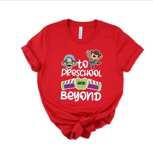 Pode incluir: Camiseta vermelha com um gr&aacute;fico branco de Woody e Buzz Lightyear de Toy Story. O gr&aacute;fico diz "To Preschool and Beyond".