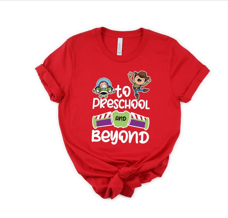 Pode incluir: Camiseta vermelha com um gr&aacute;fico branco de Woody e Buzz Lightyear de Toy Story. O gr&aacute;fico diz "To Preschool and Beyond".