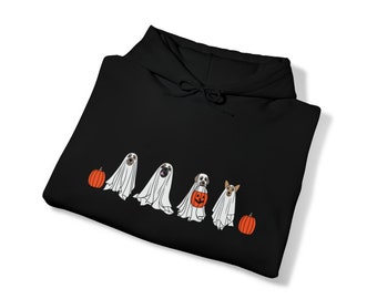 May include: Black hoodie with a Halloween-themed design. The design features four dogs in ghost costumes, each with a different expression, and two orange pumpkins. The hoodie is folded, displaying the design on the front.