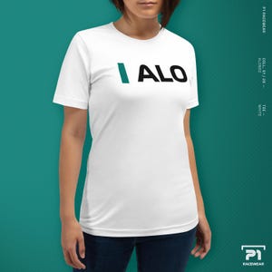 K&ouml;nnte beinhalten: Wei&szlig;es T-Shirt mit dem Text "I ALO" in Teal und Schwarz. Das kurz&auml;rmelige Shirt scheint aus einem weichen Material zu sein. Das Bild enth&auml;lt auch das P1 Racewear-Logo.