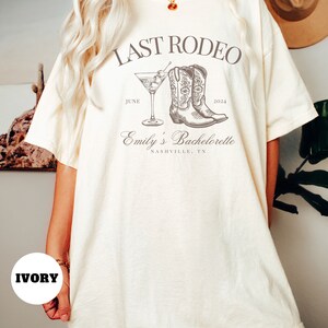 May include: Ivory t-shirt with the text "Last Rodeo" and a drawing of cowboy boots and a cocktail glass. The text "June 2024" and "Emily's Bachelorette Nashville, TN" is also included.