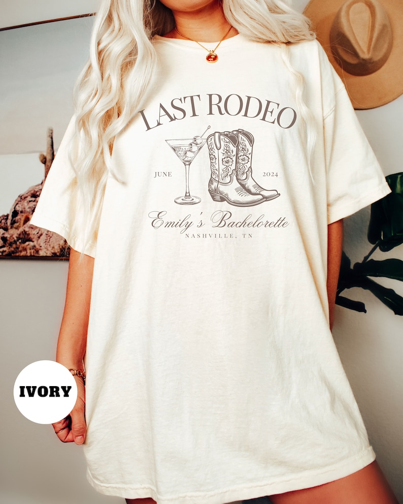 May include: Ivory t-shirt with the text "Last Rodeo" and a drawing of cowboy boots and a cocktail glass. The text "June 2024" and "Emily's Bachelorette Nashville, TN" is also included.