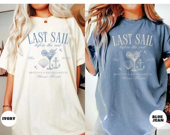 May include: Two white and blue t-shirts with the text "Last Sail Before the Veil" and a cocktail glass with a seashell and anchor graphic. The text also includes "Mar 2025" and "Brittany's Bachelorette Miami, Florida". One shirt is ivory and the other is blue jean.