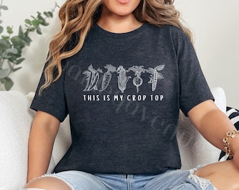 May include: A dark grey t-shirt with a white graphic of vegetables and the text "This is my crop top".
