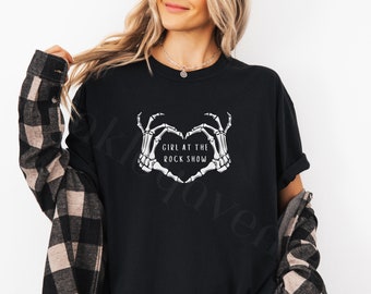 May include: Black t-shirt with a graphic of two skeleton hands forming a heart shape with the text "Girl at the Rock Show" inside the heart.