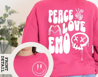 Può includere: Felpa rosa con una stampa grafica bianca sul retro che dice "Peace Love Emo" con un design di teschio e ossa incrociate. La parte anteriore della felpa ha una stampa grafica bianca che dice "It Was Never A Phase" con un motivo a scacchi.