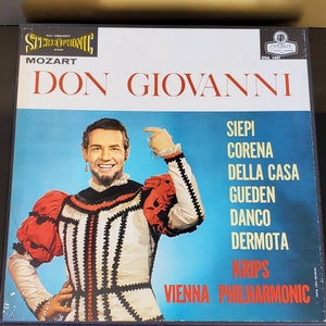 May include: A vintage vinyl record album cover for Mozart's "Don Giovanni." The cover features a portrait of a man in a costume with red and white accents against a blue background. The album title and artist names are displayed in red and white text.