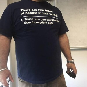 May include: A navy blue t-shirt with white text that reads: "There are two types of people in this world: 1) Those who can extrapolate from incomplete data."