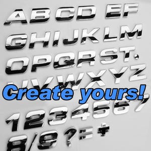 May include: A collection of individual, reflective chrome-finished letters, numbers, and symbols arranged in rows. The set includes the alphabet from A to Z, digits 0 through 9, and punctuation marks. The text "Create yours!" is overlaid in blue.