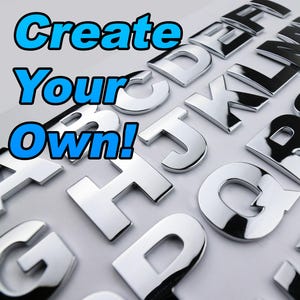 Op de afbeelding: Zilveren metalen alfabetletters op een witte ondergrond. De letters zijn in verschillende lettertypen en maten. De woorden "Create Your Own!" staan in blauw en wit boven de letters.