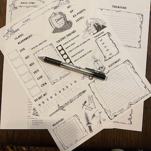 May include: A collection of white paper sheets with black ink illustrations and text, including areas for character stats, weapons, and treasure. A black pen rests on the sheets. The sheets are designed for a role-playing game.