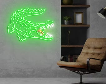May include: A green neon sign depicting an alligator with its mouth open, hanging on a gray wall. The sign is illuminated and casts a glow on the wall.