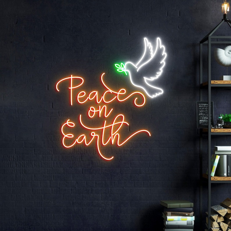 May include: A neon sign with the words "Peace on Earth" in orange and white, with a white dove carrying a green olive branch. The sign is on a dark gray wall.