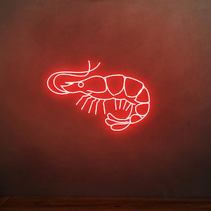 May include: A neon sign in the shape of a shrimp, glowing bright red against a dark red background. The shrimp outline is white, with details of the head, body segments, and tail. The sign is mounted on a dark wall.