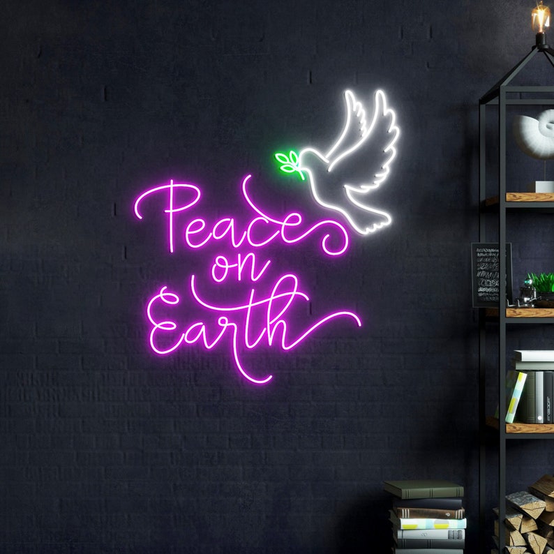 May include: Pink neon sign with the words "Peace on Earth" in a cursive font. A white neon dove with an olive branch in its beak is above the words.
