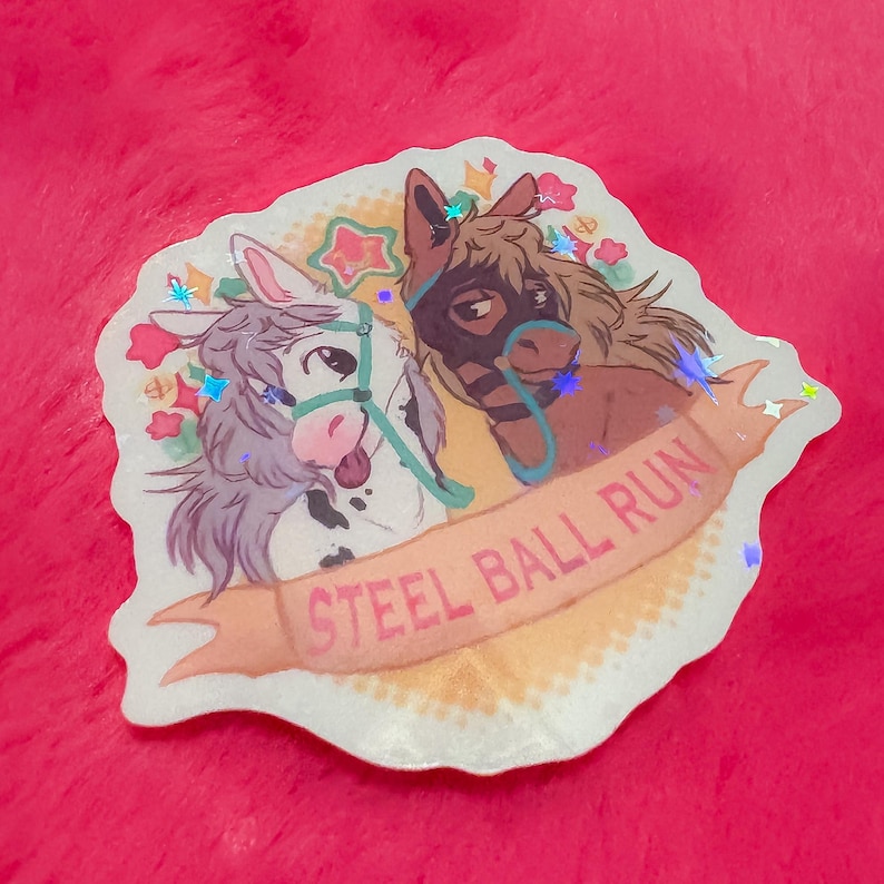 May include: A holographic sticker featuring two cartoon horses. One horse is white with a pink tongue, and the other is brown with a black mask. A banner below reads "STEEL BALL RUN" in pink letters, with stars and flowers.
