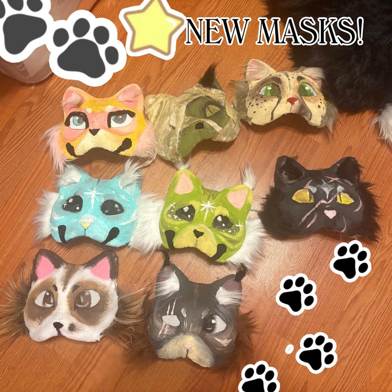 Op de afbeelding: Acht katachtige maskers met diverse geschilderde ontwerpen, kleuren en accenten van imitatiebont. De maskers tonen verschillende oogkleuren, patronen en uitdrukkingen. De tekst NEW MASKS! is bovenaan zichtbaar, vergezeld door pootafdruk-iconen.