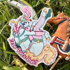 May include: A holographic sticker featuring a light blue pony with a pink bow, wearing striped leg warmers and a ruffled collar. The pony has a swirling pink plume on its head and a tan tail. The text ZERO PRICK PONY is printed in pink.
