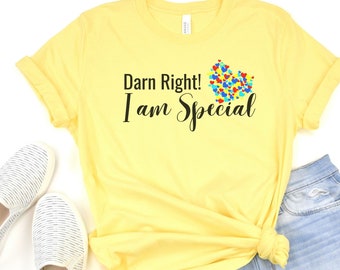 May include: Yellow t-shirt with the text "Darn Right! I am Special" and a colorful heart made of puzzle pieces.