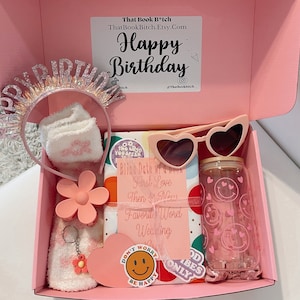 May include: Pink gift box filled with birthday gifts including a headband, socks, sunglasses, a water bottle, and a book. The box has a pink lid with the text "That Book B*tch ThatBookBitch.Etsy.Com Happy Birthday @Thatbookhitch".