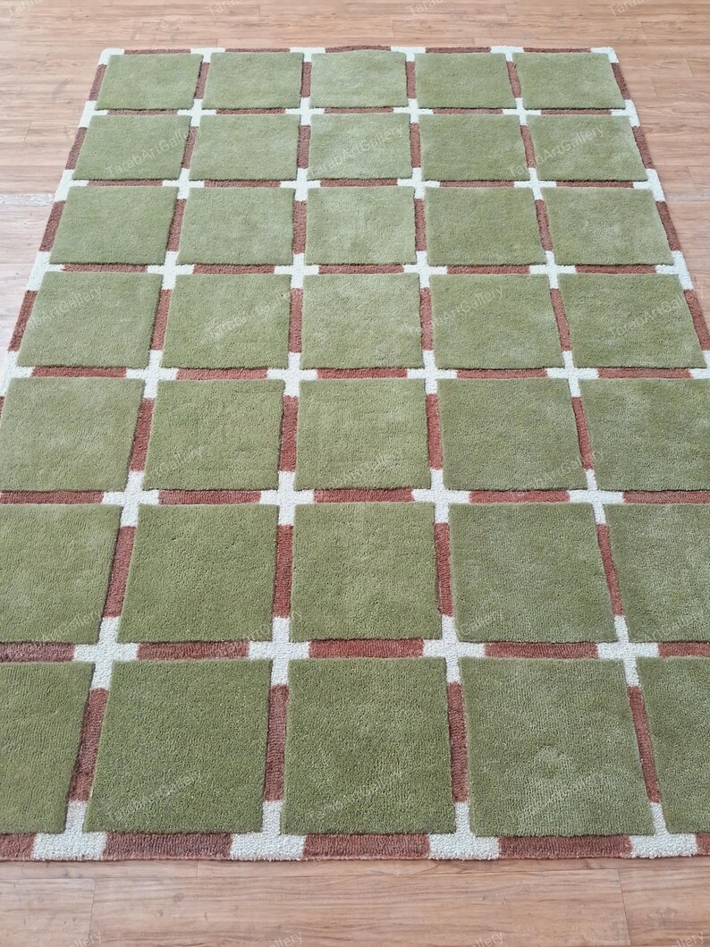 May include: A green and brown patterned rug with a grid design. The rug has a soft, plush texture.