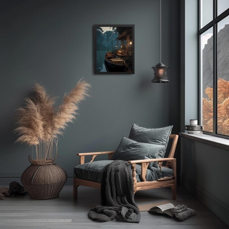 May include: A framed print of a boat on a river at dusk hangs on a dark teal wall. A wooden armchair with gray cushions and a blanket sits nearby. A large woven vase with tall, dried grasses is on the left.