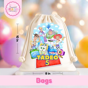 May include: A cream-colored drawstring backpack featuring a colorful graphic of various animated characters, including a cowboy, a space ranger, and a cowgirl. The name TADEO and the number 5 are printed in bold yellow and blue. It measures 10 inches by 8 inches.