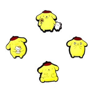 May include: Four yellow enamel pins featuring a cartoon dog character with a red beret. Some pins include a small white animal or a yellow flower. The pins have black outlines and are set against a white background.