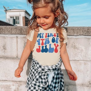 a little girl standing on top of a cement wall