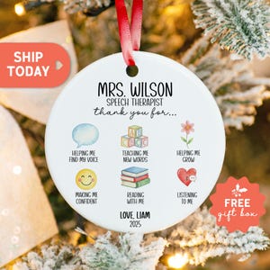 May include: A white ceramic ornament with a red ribbon for hanging. The ornament features the text "MRS. WILSON SPEECH THERAPIST thank you for..." and various icons with text. The bottom of the ornament reads "LOVE, LIAM 2025".