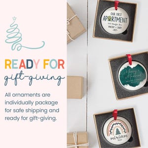 three christmas ornaments in a gift box with a red ribbon