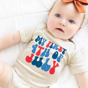 a baby laying on a bed with a bow in its hair
