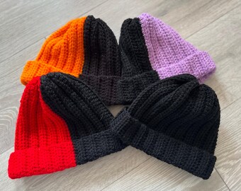 May include: Four crocheted hats in different colors. The hats are made of black and orange yarn, black and red yarn, black and purple yarn, and black and red yarn.