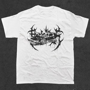 Puede incluir: Camiseta blanca con un estampado gráfico negro de un coche con un diseño de llama estilizado.