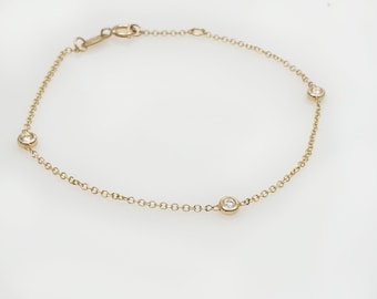 May include: A gold chain bracelet with three small round diamonds.