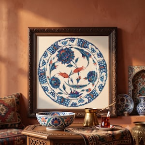 Peut inclure: Une broderie au point de croix encadrée présentant un motif floral circulaire dans des tons de bleu, rouge et blanc. Le design affiche des fleurs et des feuilles stylisées disposées en une composition symétrique, sous un cadre en bois orné.