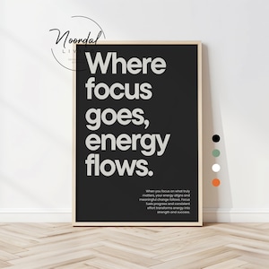 Könnte beinhalten: Ein gerahmter Schwarz-Weiß-Druck mit dem Text "Where focus goes, energy flows." Der Druck hat einen hellen Holzrahmen und wird vor einer weißen Wand ausgestellt. Der Druck enthält auch einen kleineren Text am unteren Rand.