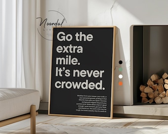 May include: A framed black and white print with the text "Go the extra mile. It's never crowded." The print has a gold frame and is displayed near a fireplace and a modern sofa. The print also has the text "Noordal Living" at the top.