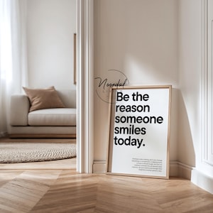 Könnte beinhalten: Ein gerahmter Druck mit dem Text "Be the reason someone smiles today" in minimalistischem Stil. Der Druck befindet sich in einem hellen Holzrahmen und lehnt an einer Wand. Der Raum hat eine neutrale Farbpalette mit einem Sofa und einem Teppich.